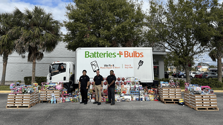 Batteries Plus Powers the Season of Giving Image of Batteries Plus team members with Truck donating batteries and toys to Toys For Tots