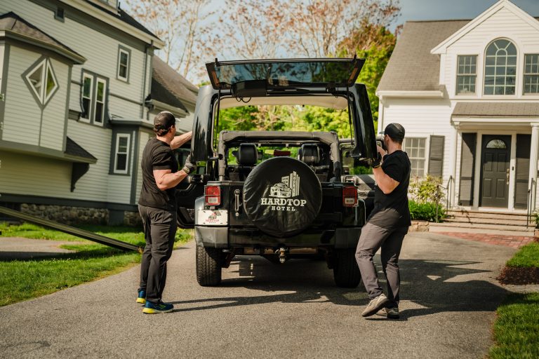 Two employees of Hardtop Hotel removing a Jeep Wrangler Top