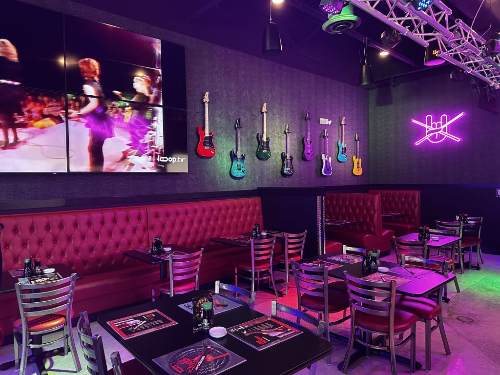 Rock N Roll Sushi Interior with tables, neon lights, red velvet tufted seating and guitars