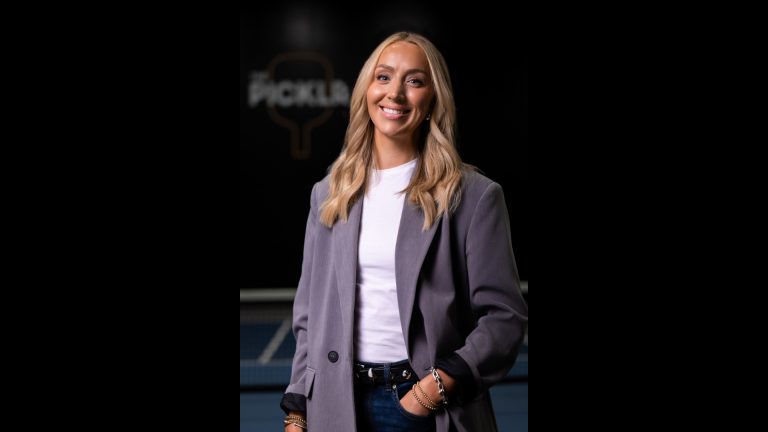 Abby Olson smiling while standing on an indoor pickleball court at The Picklr.