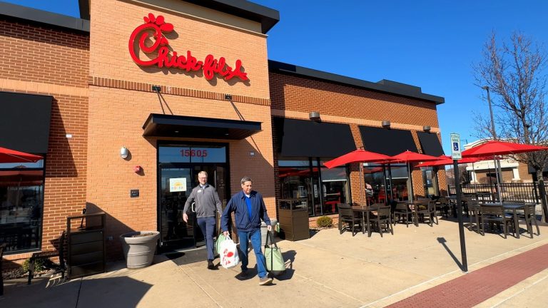 Two men exiting Chick-fil-A restaurant.