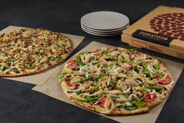 New Creamy Parm Pizzas Debut at Donatos for the Holiday Season Two Donatos pizzas made with the new Creamy Parm Sauce on display beside pizza boxes
