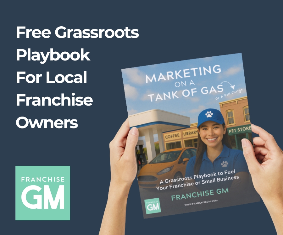 Hands holding a Franchise GM marketing playbook for local franchise owners focused on grassroots marketing.
