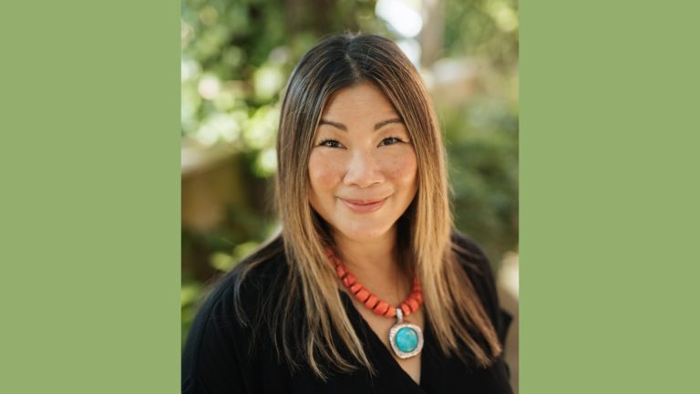 Cathy Tang, Chief Legal Officer at QDOBA, smiling outdoors in a professional portrait