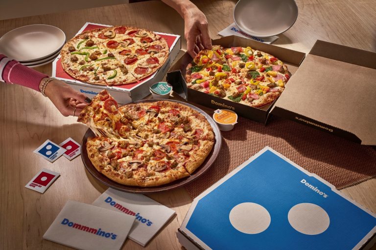 Domino’s Brings Back $9.99 ‘Best Deal Ever’ Pizza Promotion for College Basketball Tournament Domino’s pizzas with multiple toppings on a table during a watch party