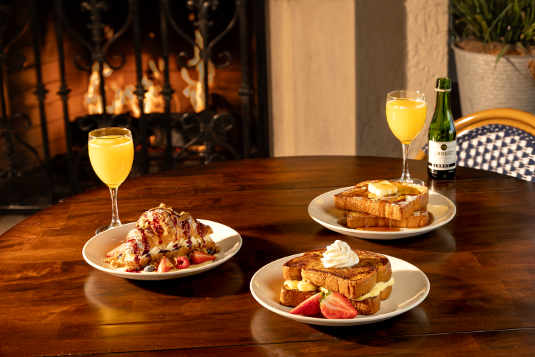 French toast dishes and brunch items with mimosas on a table at la Madeleine