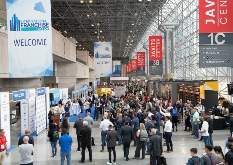 Crowd gathers beneath International Franchise Expo banners at the Javits Center in New York City