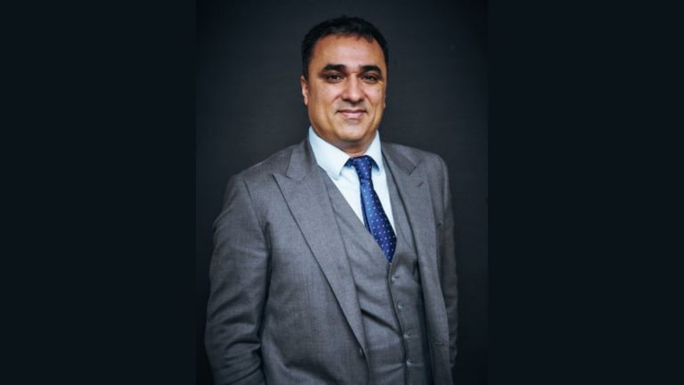 Keyrenter Property Management Appoints Kioumars Amini as Senior VP of Franchise Development Kioumars Amini in a gray suit posing for a professional portrait