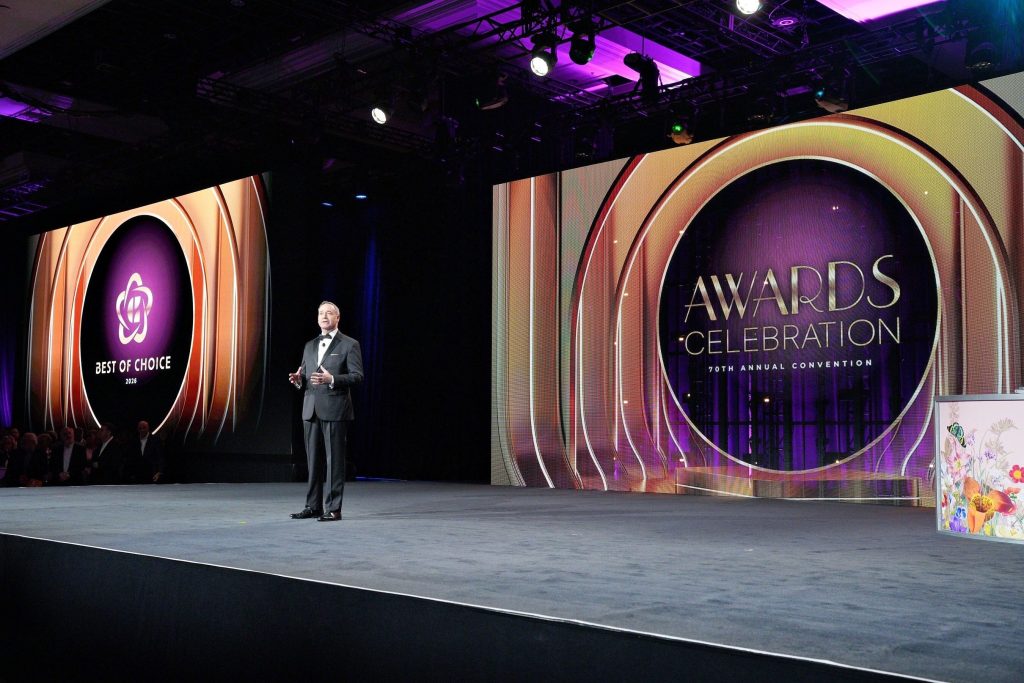 Choice Hotels executive speaks on stage during 70th Annual Convention awards celebration