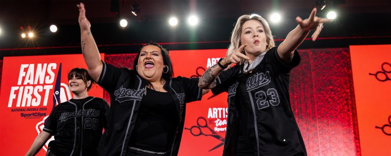 Sport Clips team members celebrate on stage at 2026 National Huddle