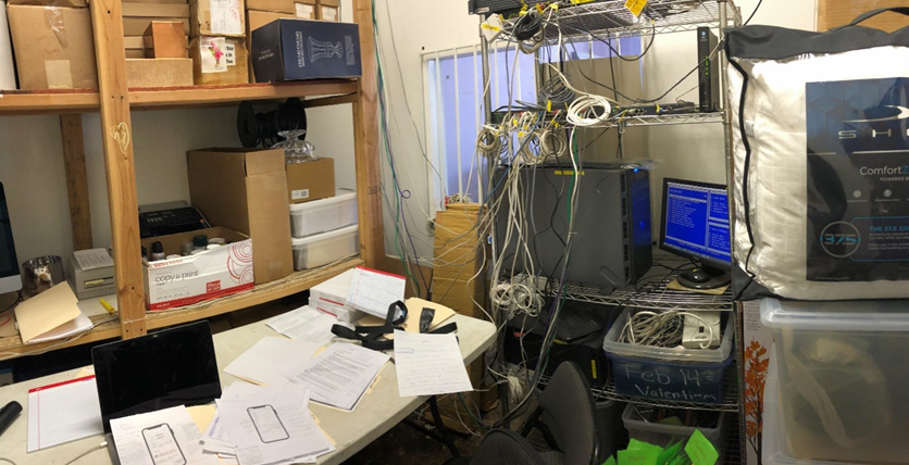 The cluttered back office of a traditional flower shop with tangled wires, stacked papers, and outdated equipment that Michael Jacobson inherited.