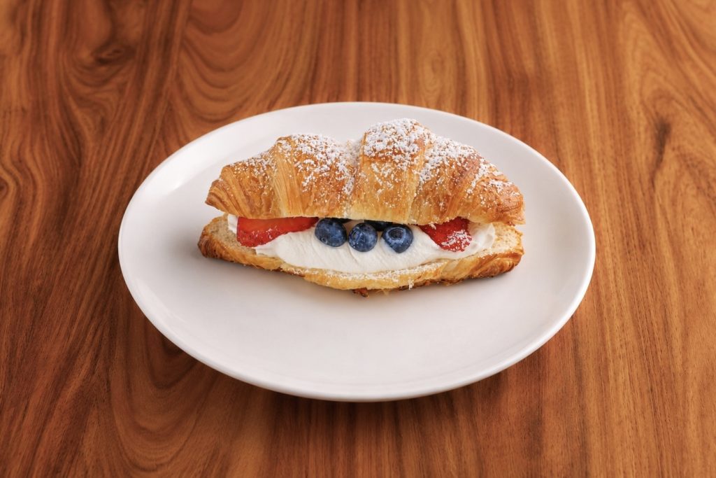 Red, White & Blue Croissant with strawberries and blueberries on a white plate