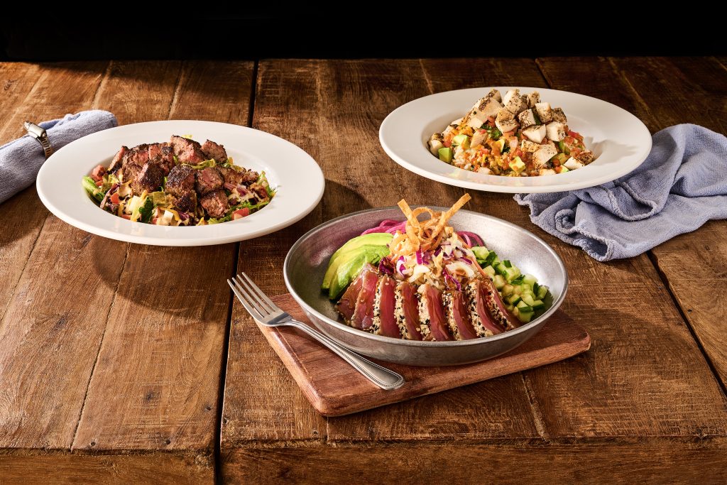 Seared ahi tuna bowl beside steak and chicken salads at Ford's Garage