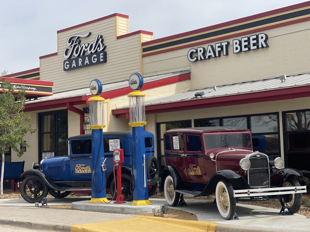 Vintage Ford vehicles parked outside a Ford's Garage restaurant exterior