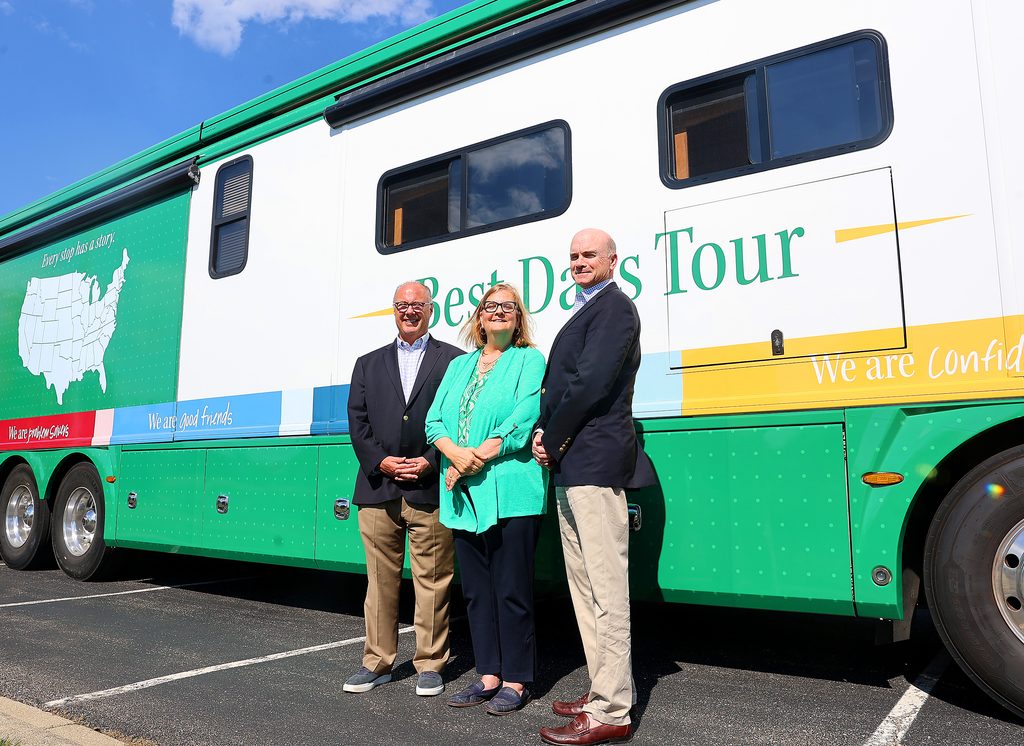 William Stewart, Glee McAnanly and Bernard Markey stand in front of the FirstLight Home Care Best Days Tour RV